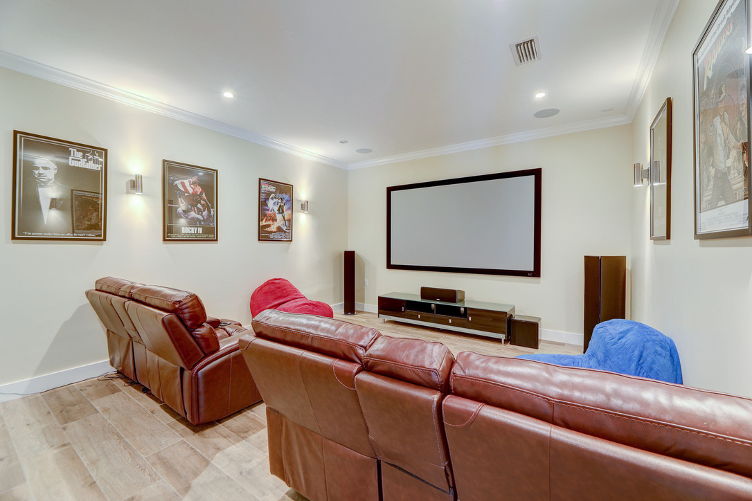 Home theater room featuring a large projector screen and surround sound system.